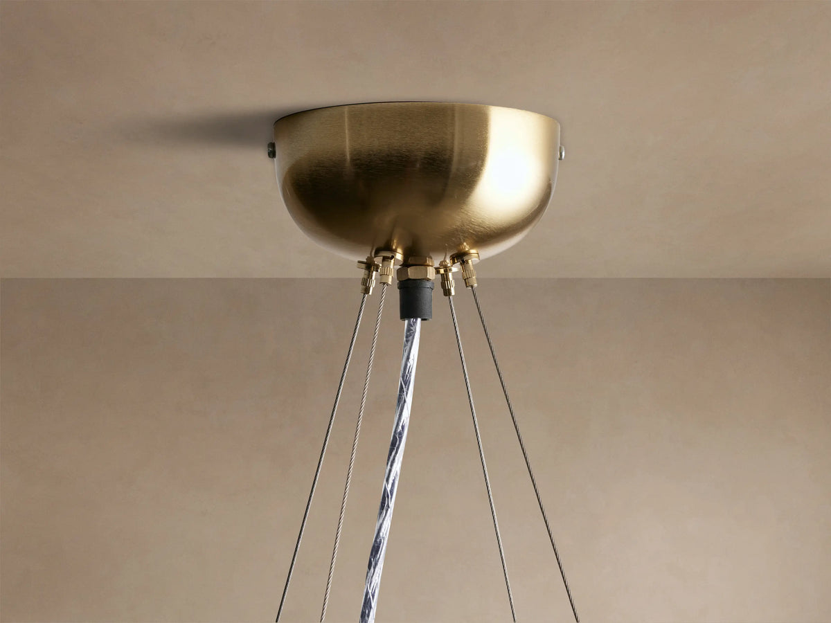 Jeunet Round Chandelier, round with antiqued brass geometric frame and white frosted glass panels, glowing warmly.
