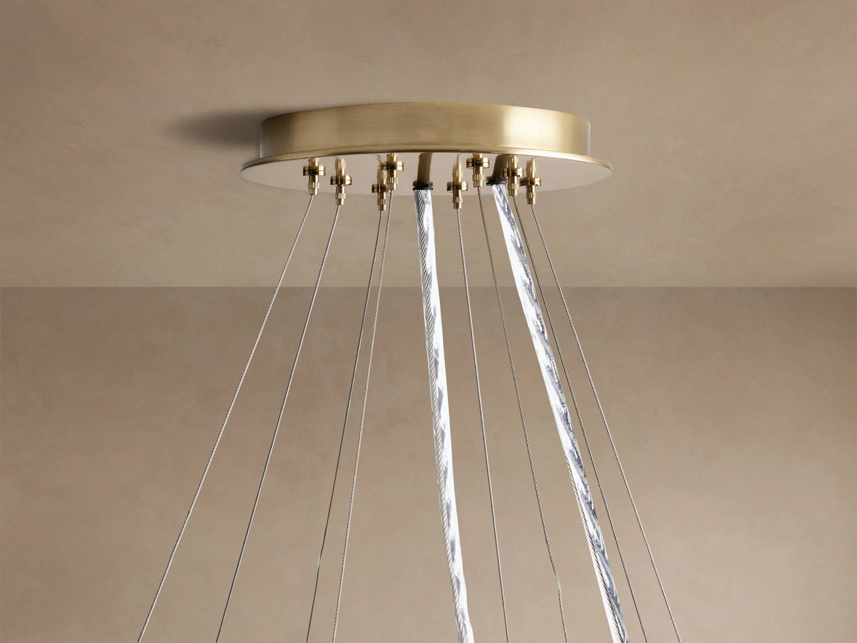 Close-up of Jeunet 2-Tier Round Chandelier with antiqued brass frames and illuminated translucent panels, casting warm light.