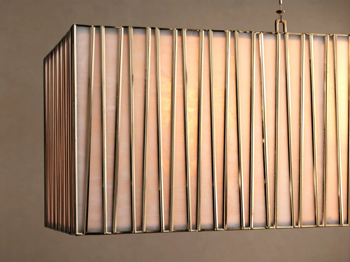 Jeunet Rectangular Chandelier with antiqued brass frame & vertical glass panels, hanging by two cables against a beige wall.
