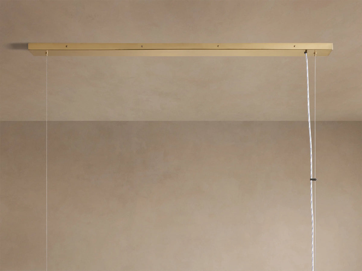 Angled close-up of Jeunet Rectangular Chandelier. Antiqued brass frame, vertical slats, and glowing soft light from within.