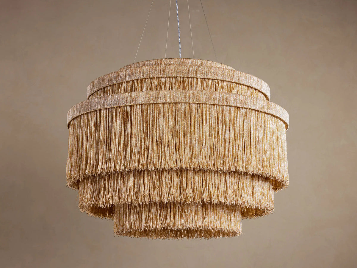 Romilly Tiered Chandelier, three concentric layers of glowing golden glass beads, illuminated from within, hanging.
