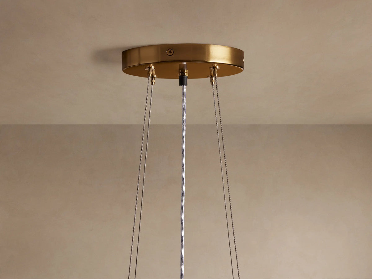 Romilly Tiered Chandelier with three tiers of shimmering light brown glass bead fringe, glowing warm orange from within.