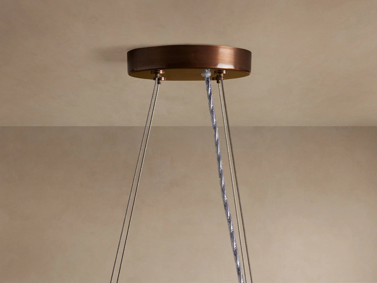Romilly Round Chandelier: close-up of antiqued bronze ceiling canopy, silver support wires, and twisted grey electrical cord.
