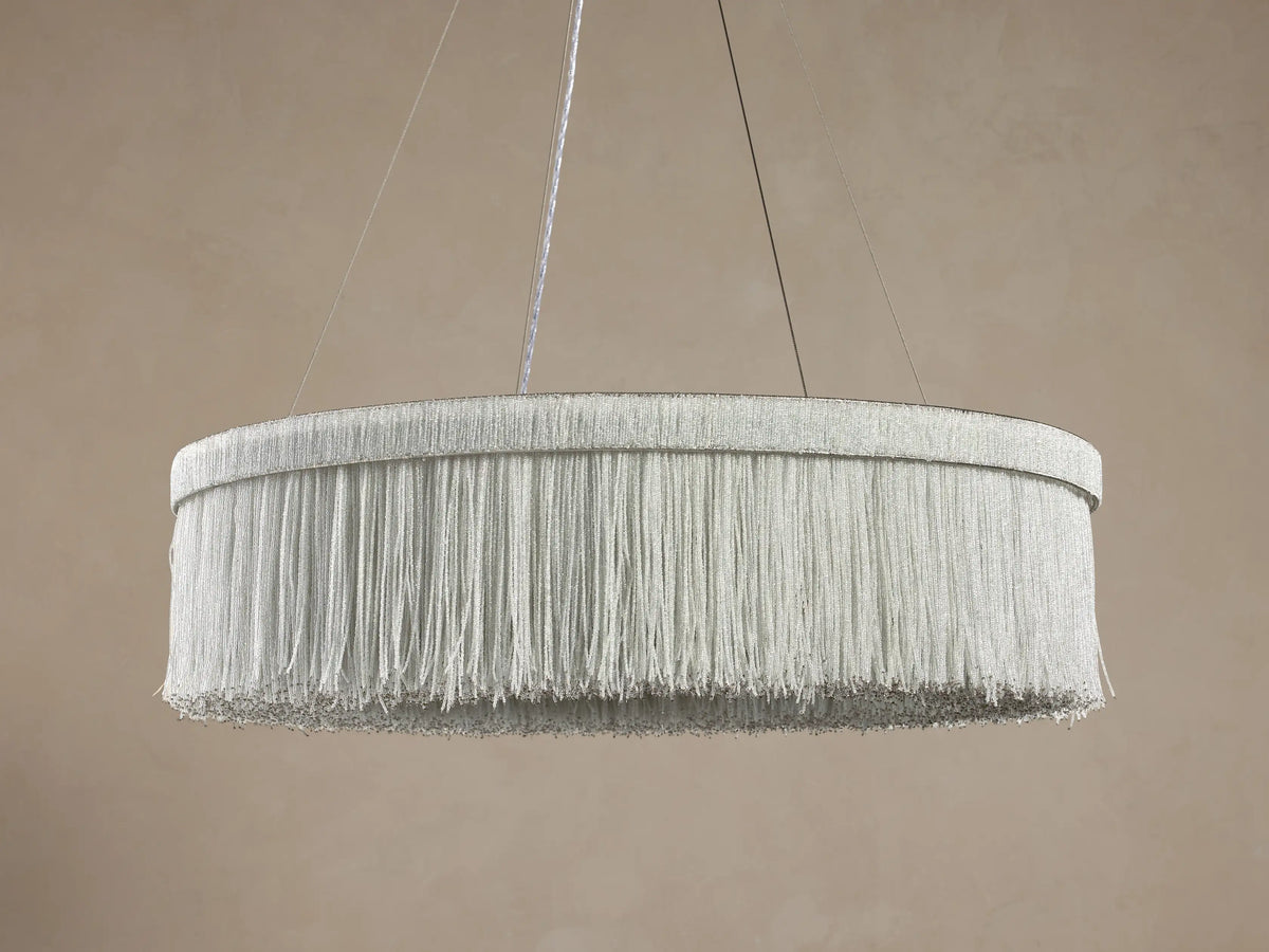 Romilly Round Chandelier: Suspended round chandelier with fringe-like strands of small, light gray glass beads on a soft brown background.