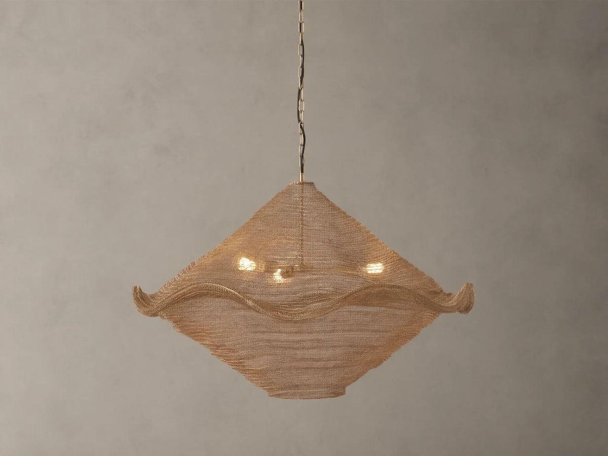 Mirza Sphere Chandelier. Draped woven antique brass mesh in a square shape with wavy edges, 3 glowing bulbs inside, hanging.