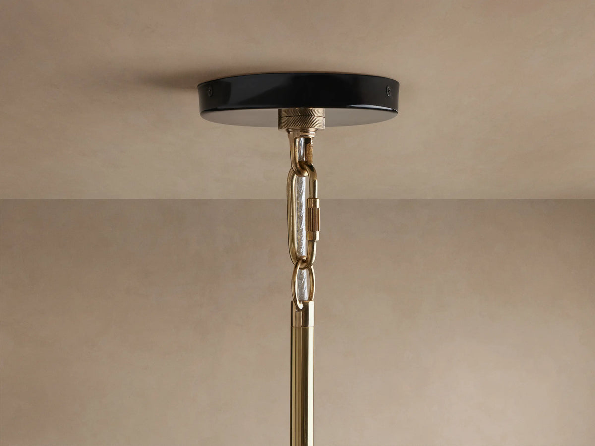 Close-up of Bonham Pendant featuring a glossy black exterior and a luminous brass interior with a warm glowing light.