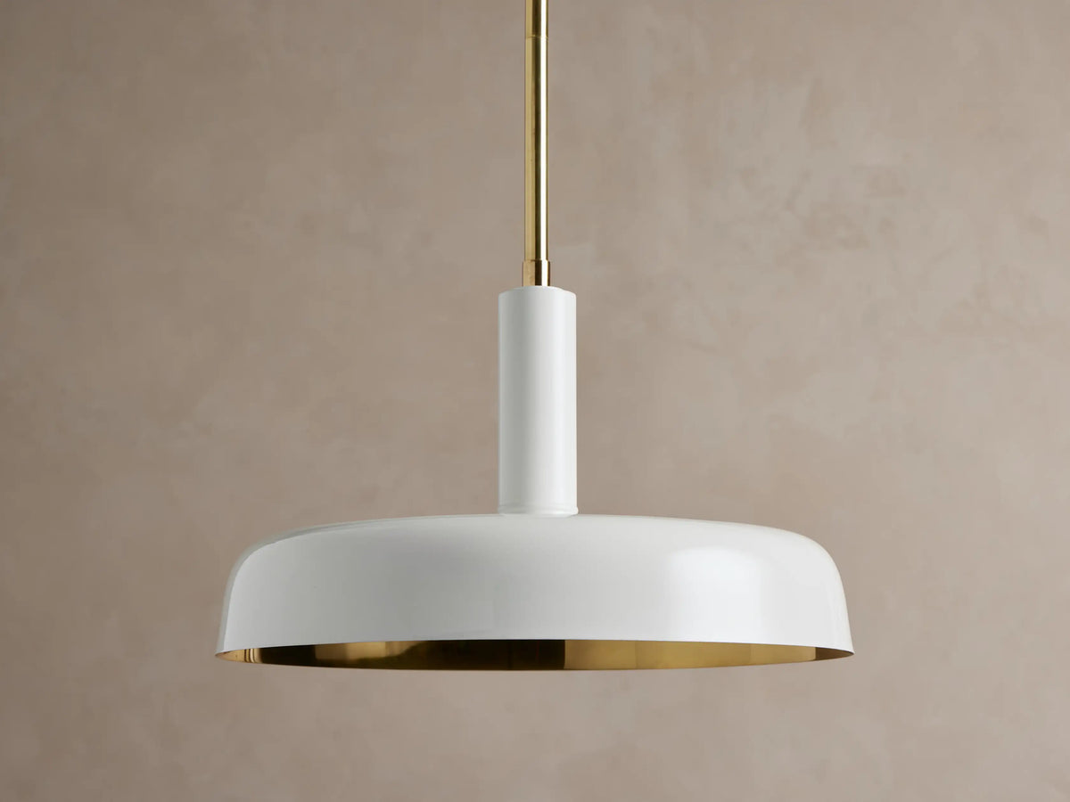 Bonham Pendant: white dome-shaped pendant light with a gold hanging rod, brass interior, and a warm glow from within.