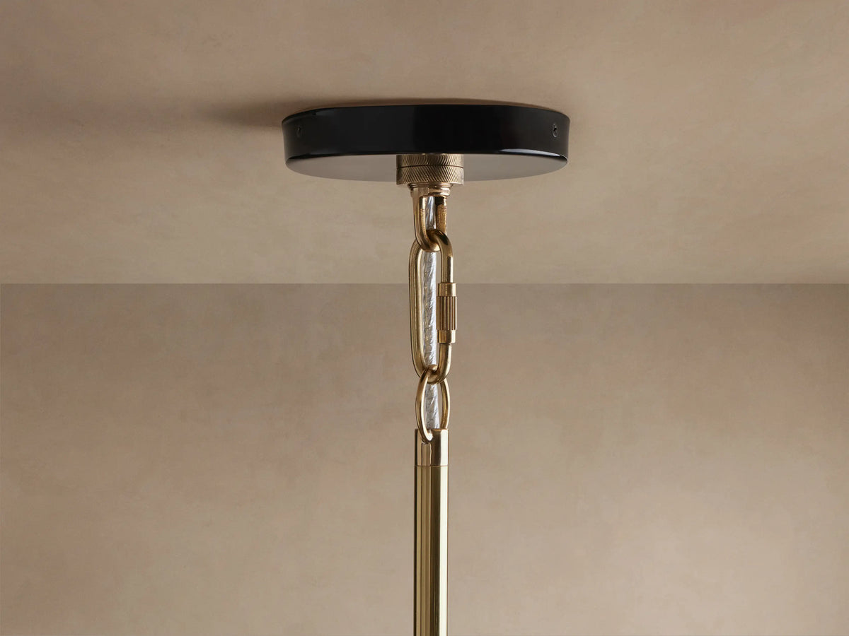 Bonham Pendant: close-up, black powder-coated top, shining brass interior with warm glowing bulb, viewed from below.
