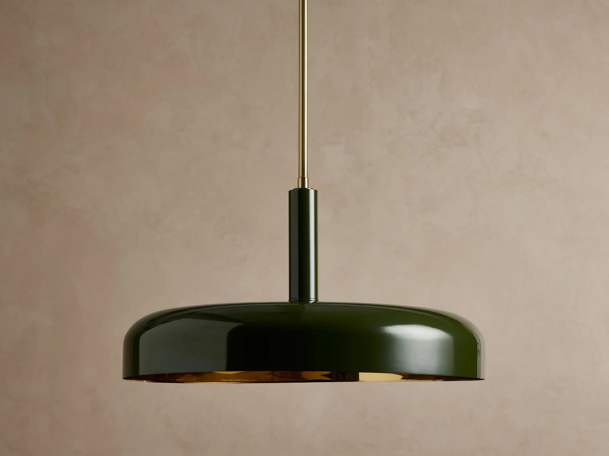Bonham Pendant: Dark green, disc-shaped pendant light with a glossy finish & glowing brass interior, suspended by a brass rod.