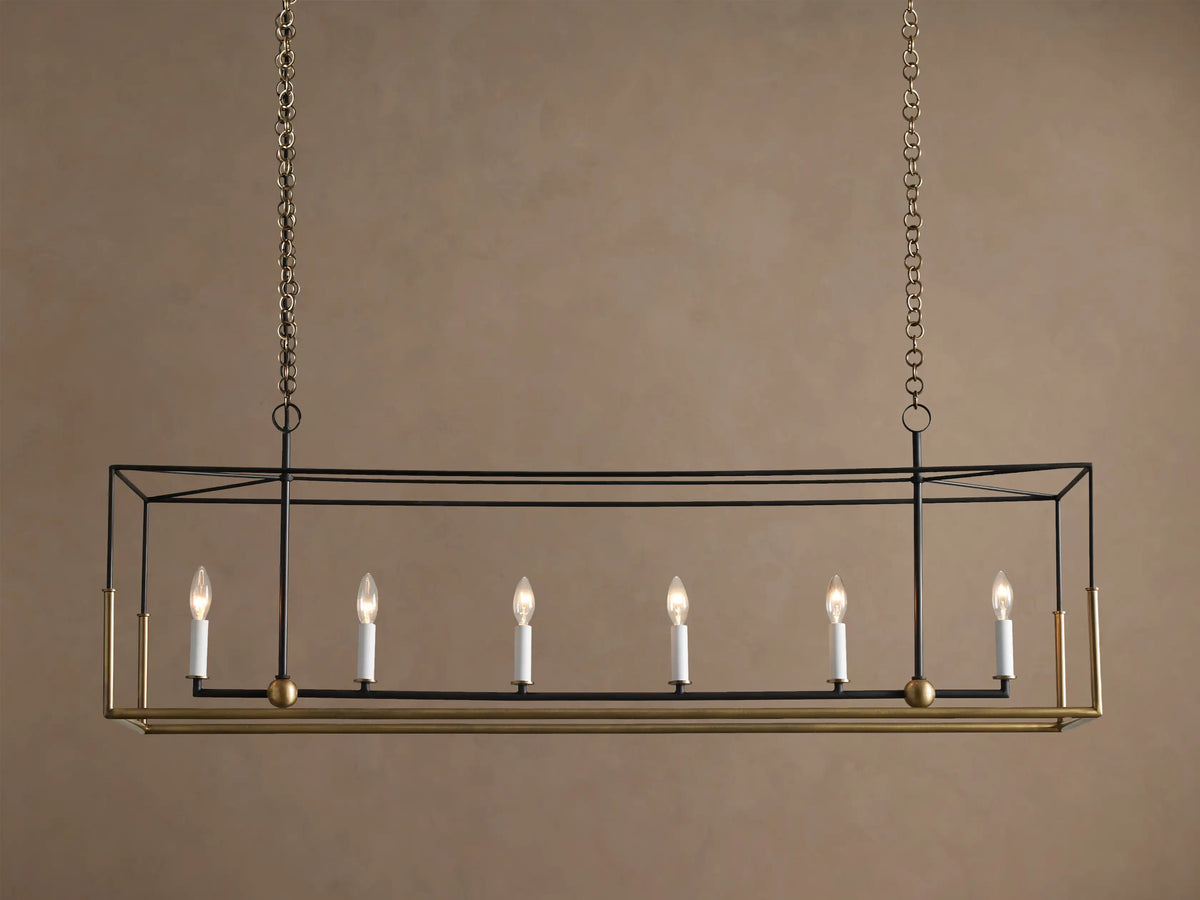 Holt Linear Chandelier. Black rectangular frame with antique brass base, hanging from chains. Six illuminated candle-style bulbs.