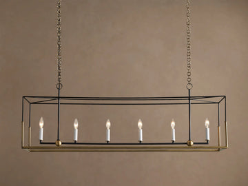 Holt Linear Chandelier. Black rectangular frame with antique brass base, hanging from chains. Six illuminated candle-style bulbs.