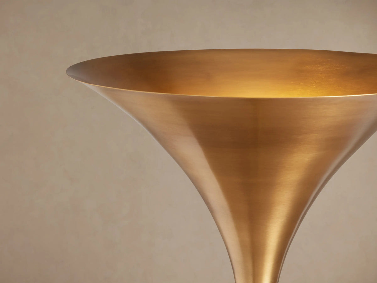 Tall Tultz Floor Lamp with burnished brass finish, tulip-shaped shade, slender pole, and round base on wooden floor.