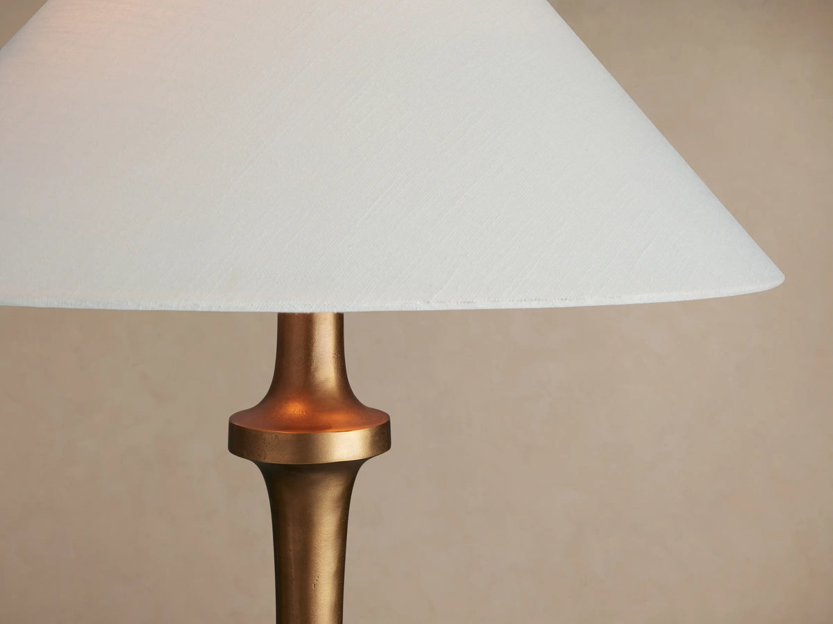 Murphy Floor Lamp with a brass finish, conical base, slender stem, and white tapered linen shade.