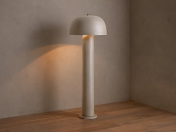 Front view of the beige Mushroom Floor Lamp with cylindrical body and dome shade, emitting warm light.