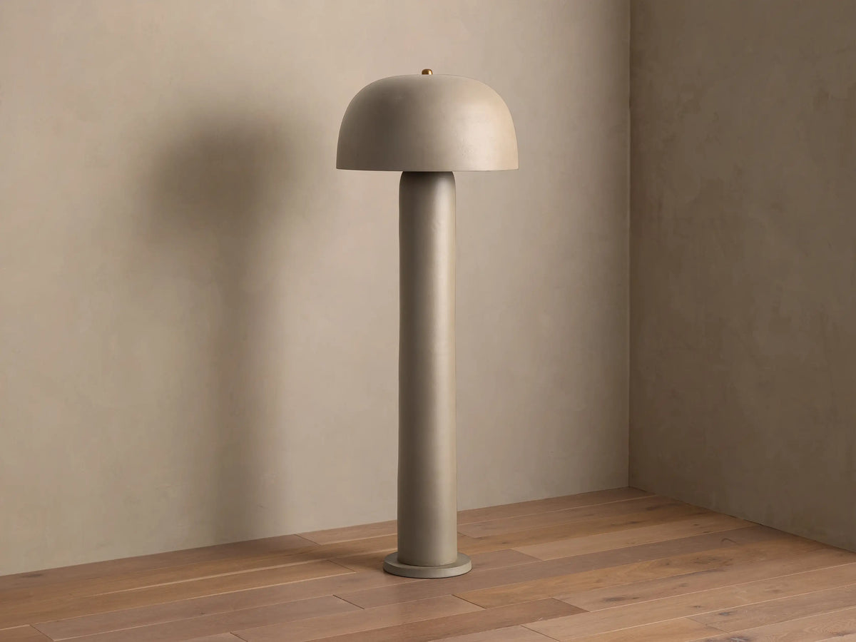 Front view of the beige Mushroom Floor Lamp with cylindrical body and dome shade, emitting warm light.
