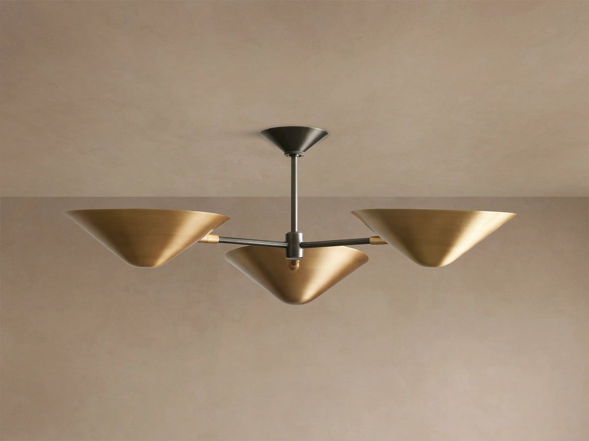 Simms Flush Mount light fixture with three golden, cone-shaped shades extending from a dark central rod, mounted on a ceiling.