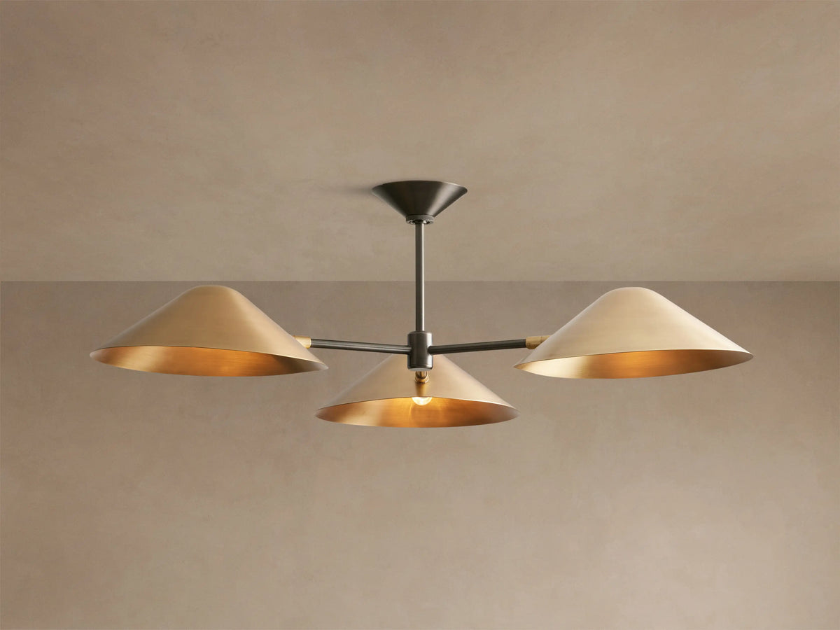 Simms Flush Mount with three polished brass cone shades on an antiqued bronze central rod, mounted on a beige ceiling.