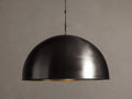 Watley Dome Pendant: Large dark dome with a polished, glowing antique brass interior, suspended from a dark chain.