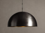 Watley Dome Pendant: Large dark dome with a polished, glowing antique brass interior, suspended from a dark chain.