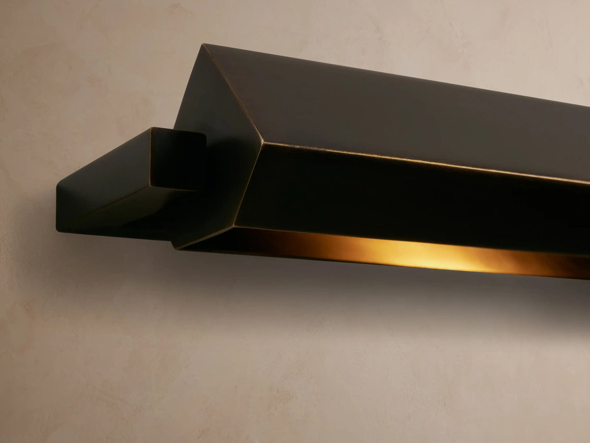 Zaeden Picture Light, dark bronze-plated iron, mounted horizontally on a wall. It has a long, angular bar and rectangular backplate.