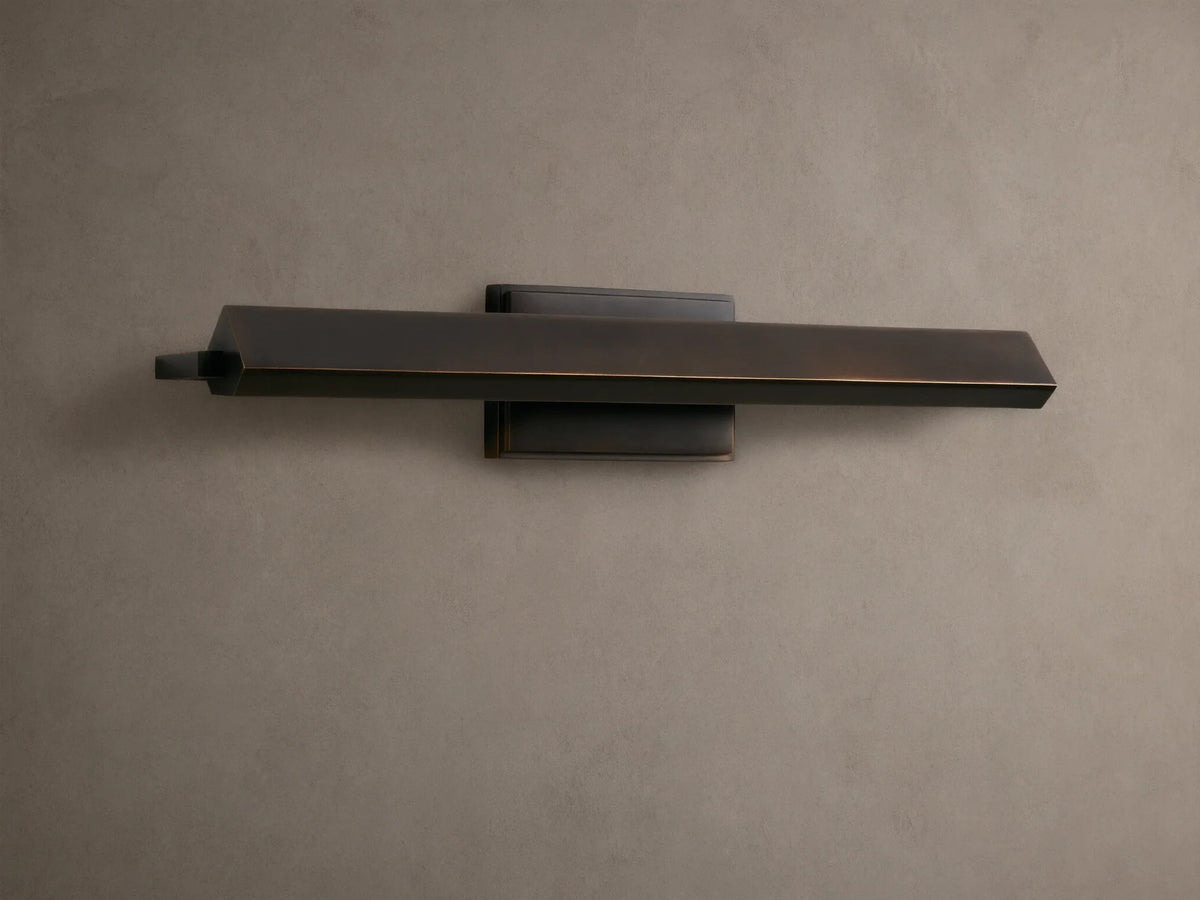 Zaeden Picture Light: Bronze-plated iron horizontal bar light mounted on a neutral wall, highlighting its metallic finish.