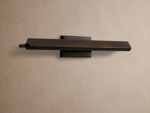 Zaeden Picture Light: Bronze-plated iron horizontal bar light mounted on a neutral wall, highlighting its metallic finish.
