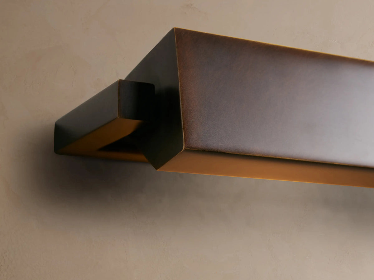 Zaeden Picture Light: angular bronze-plated iron fixture, dark brown, mounted on a textured light brown wall, side view.