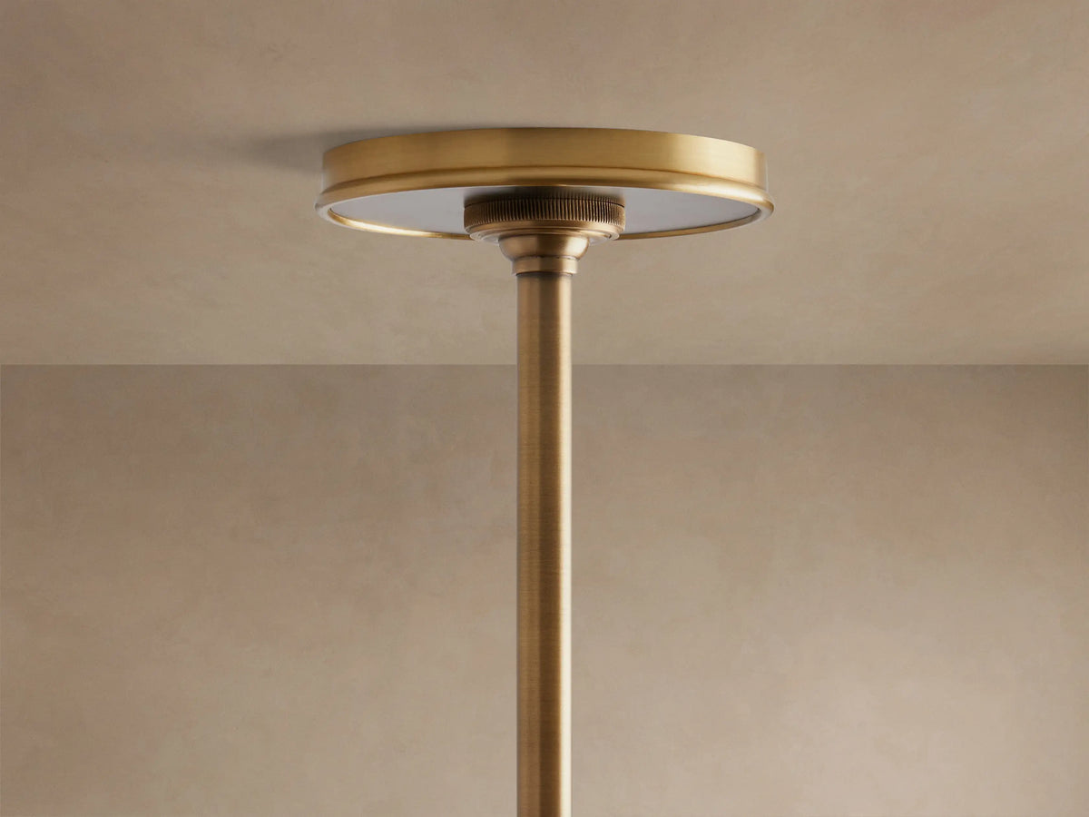 Close-up of Arno Linear Chandelier featuring a matte black conical shade with a shiny brass interior, suspended from a brass rod.