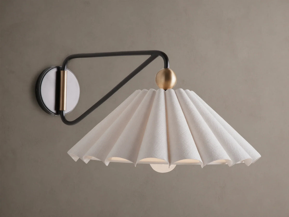 Illuminated Haylen Sconce: black metal arm, circular backplate with antique brass, pleated cream fabric shade.