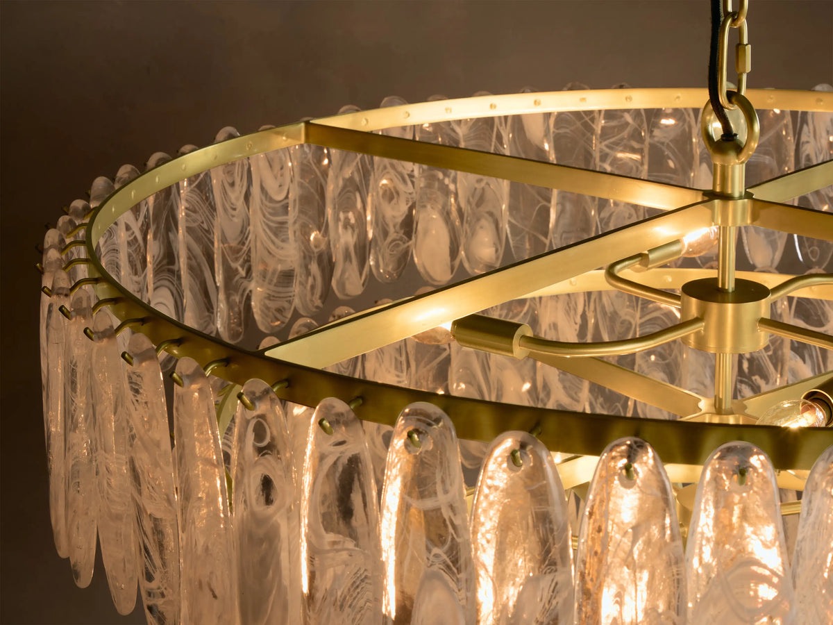 Close-up of layered, clear elongated glass elements with white and gray swirled patterns, illuminated by warm golden light.