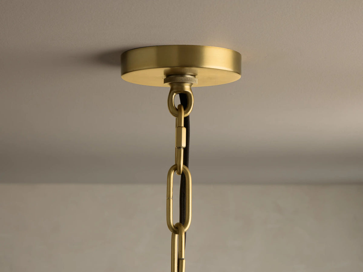 Front view of a gold-toned, three-tier chandelier with clear, textured glass drop-shaped pieces.