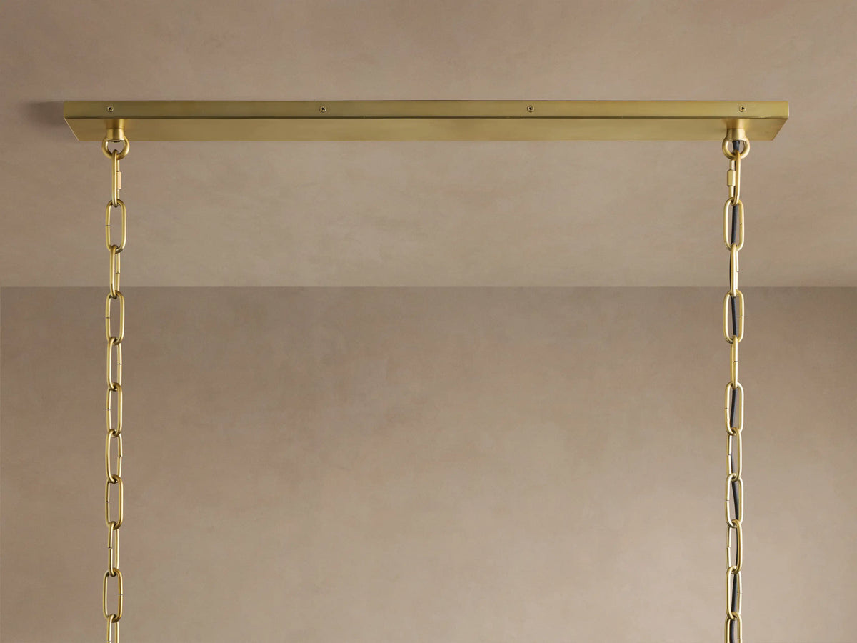 Gold rectangular chandelier, two tiers of illuminated clear oval glass with frosted swirls, suspended by chains.