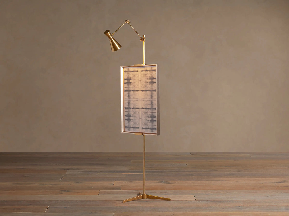 Close-up of the Jaxtyn Easel Floor Lamp's adjustable cast brass art display support and vertical pole with adjustment knob.