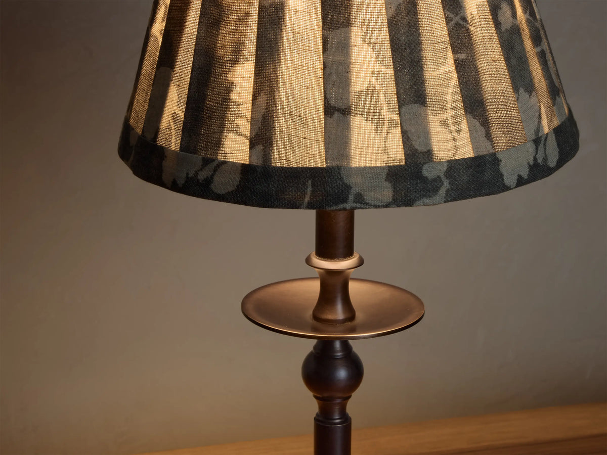 Front view of the Bronze Winslow Accent Table Lamp with a pleated dark gray fabric shade featuring a light floral pattern.