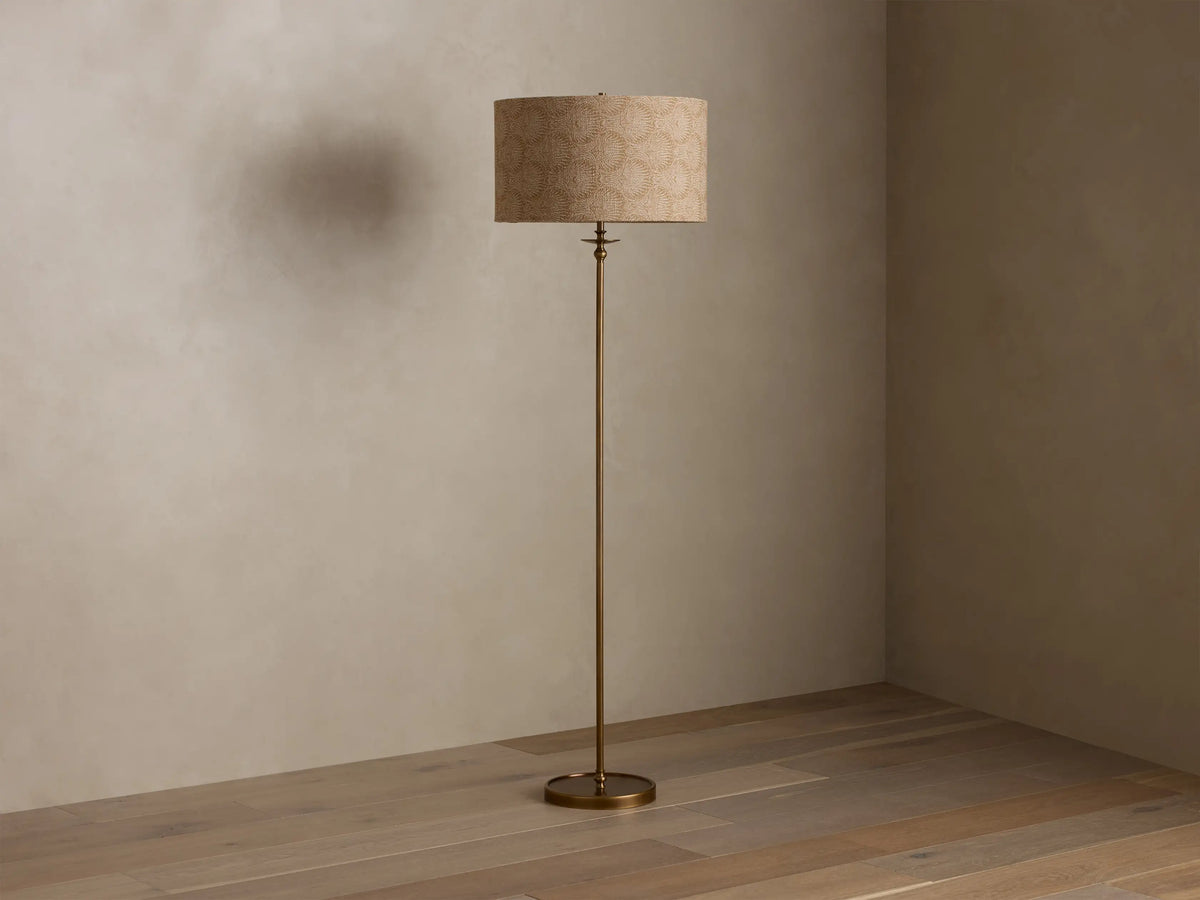 Front view of the Winslow Floor Lamp with an antique brass finish and a beige patterned fabric shade.