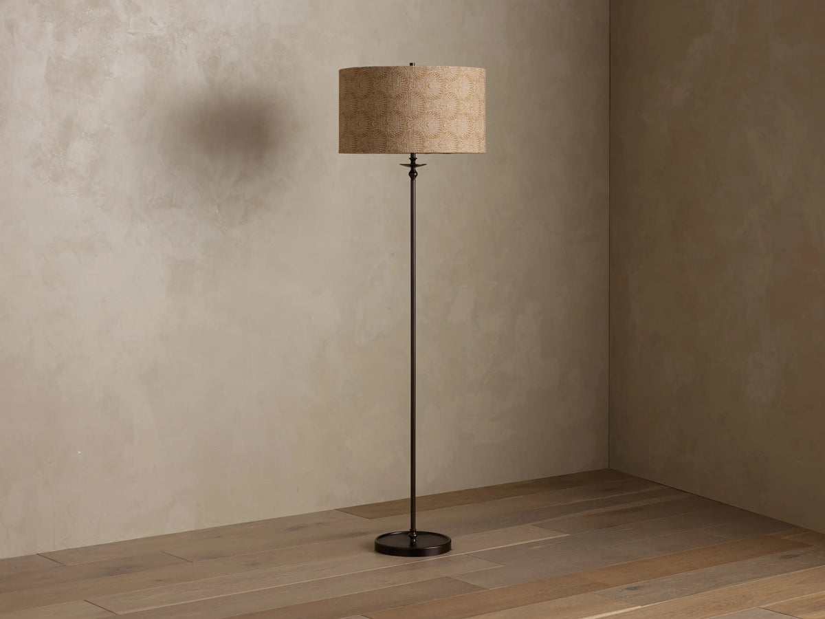 Front view of a Bronze Winslow Floor Lamp with an illuminated, cylindrical textured beige fabric shade.