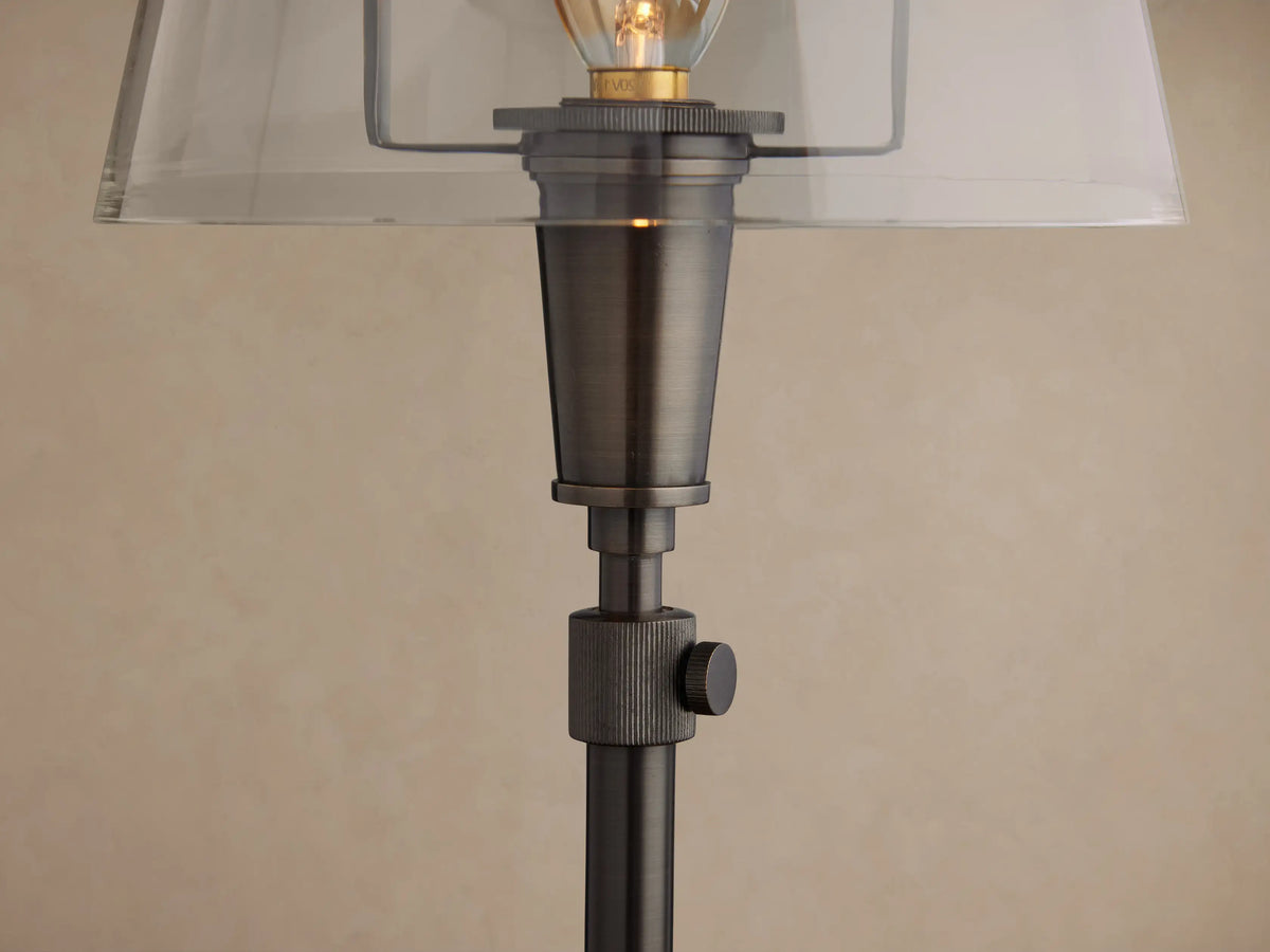 Candice Table Lamp in pewter finish, featuring a clear bell-shaped shade with an exposed filament bulb, on a wooden surface.
