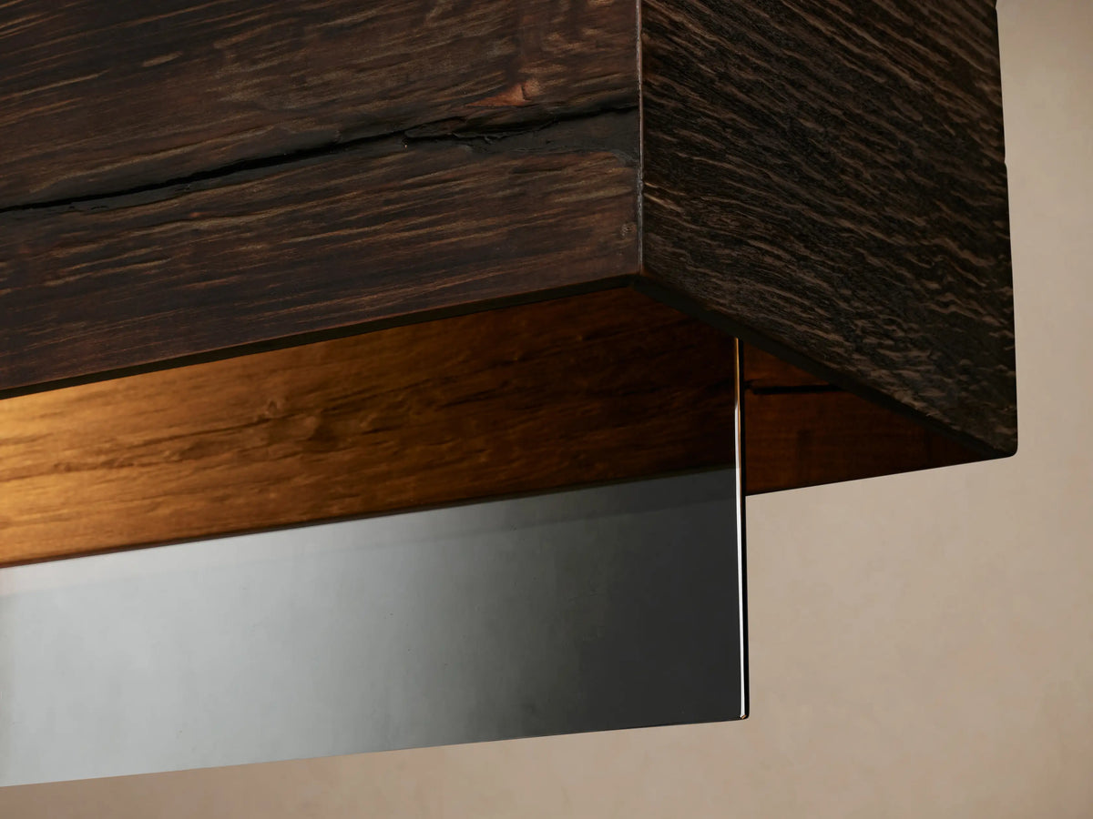 Lena Linear Chandelier: Horizontal dark alder wood bar with a mirrored glass panel, suspended by two black cords.