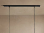 Lena Linear Chandelier close-up: dark, textured alder wood, glowing ochre interior, and reflective mirrored glass panel.