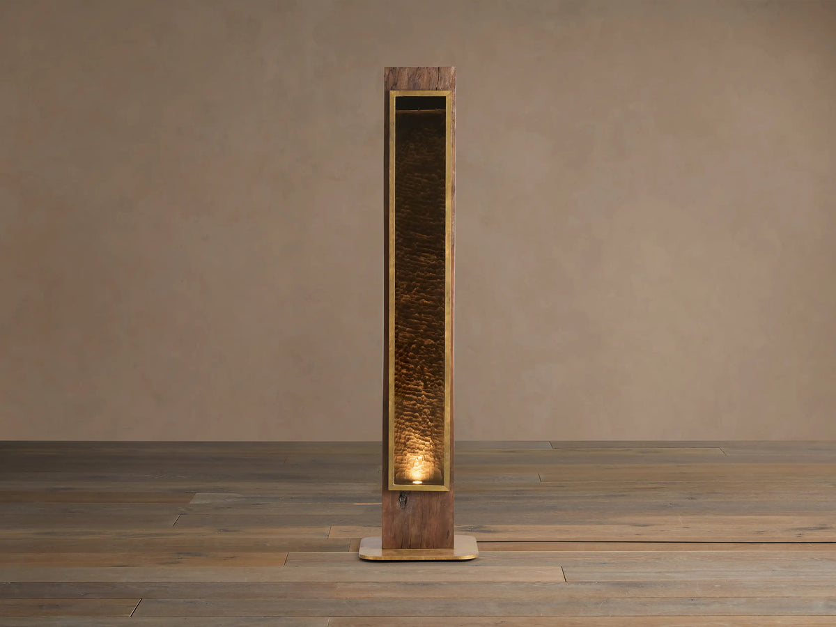 Vigas Floor Lamp: Tall wooden lamp with brass trim, illuminated mirrored glass revealing a textured interior, standing on wood floor.