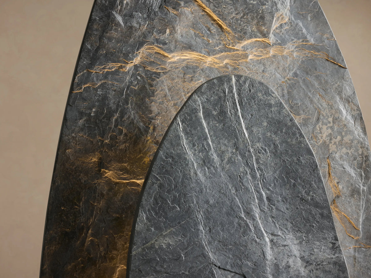 Two layered dark gray slate stones with white veins on a light wood base, forming the Shinto Floor Lamp, on a wooden floor.