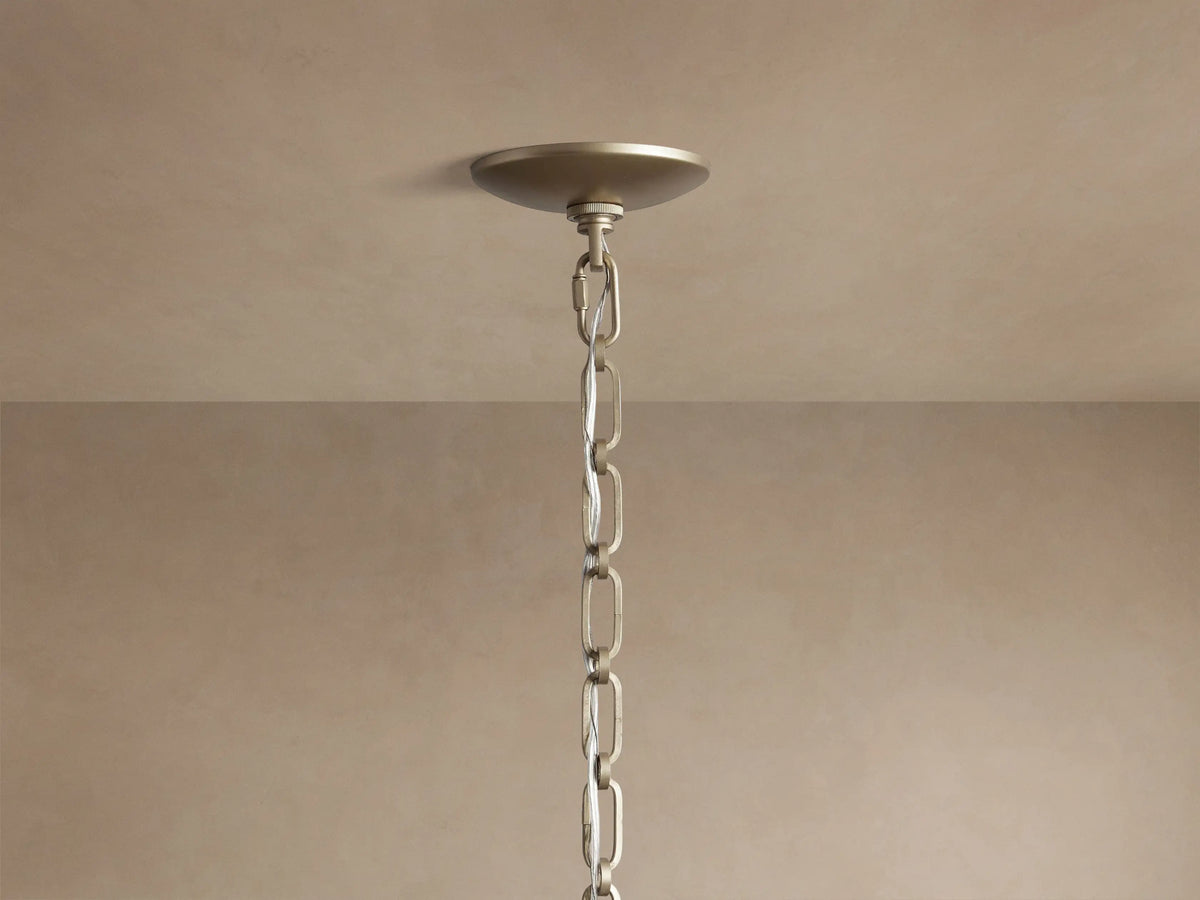 Margolis Large Pendant. White segmented hand-blown glass orb, encased by a brass-finish iron frame, against a neutral background.