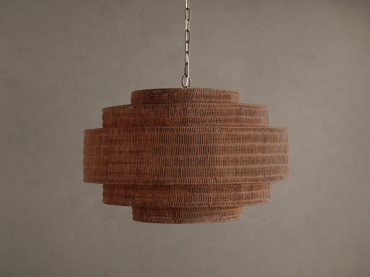 Paloma Chandelier with a tiered, cylindrical handwoven brown rattan shade, suspended from a metal chain against a plain background.