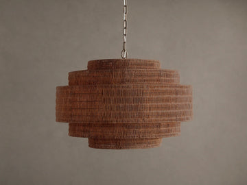 Paloma Chandelier with a tiered, cylindrical handwoven brown rattan shade, suspended from a metal chain against a plain background.