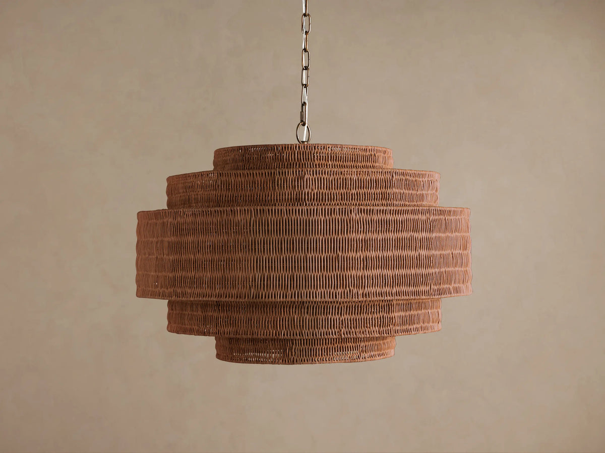 Paloma Chandelier with a tiered, cylindrical handwoven brown rattan shade, suspended from a metal chain against a plain background.