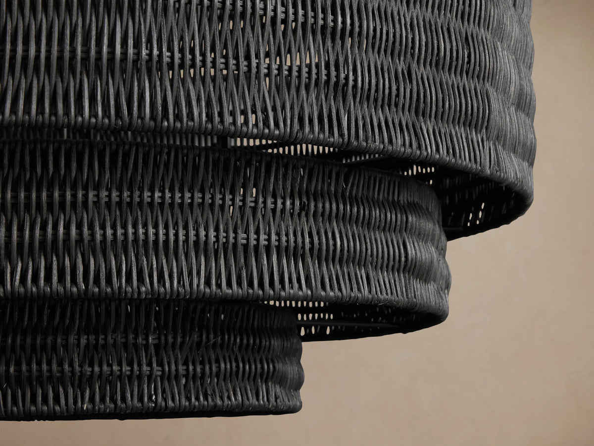 Black Paloma Chandelier with tiered, handwoven rattan shade, hanging from a dark chain.