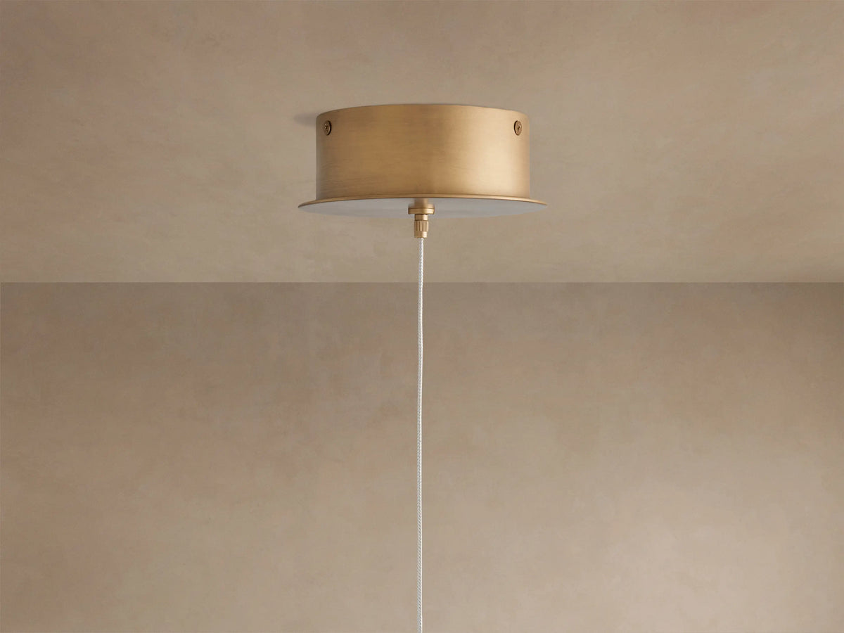 Close-up of the Arica Pendant's curved, textured natural alabaster shade with muted pink tones, glowing warmly from within.
