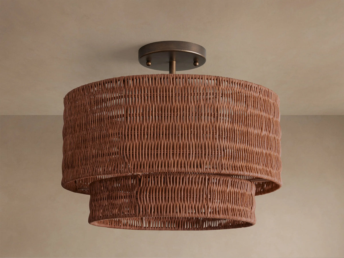 Paloma Flush Mount light with two-tiered handwoven brown rattan shade, metallic bronze canopy, illuminated against a light ceiling.