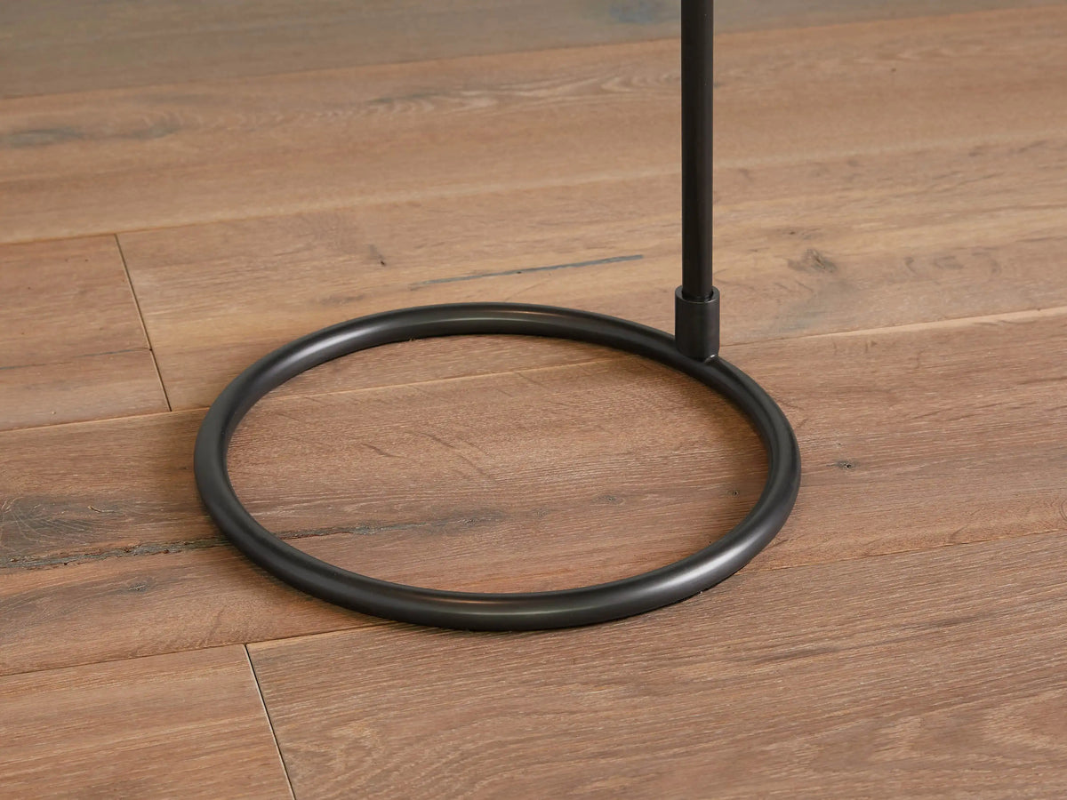 Close-up of Kellen Floor Lamp's adjustable oil-rubbed bronze arm holding a large, light cream linen shade against a warm wall.