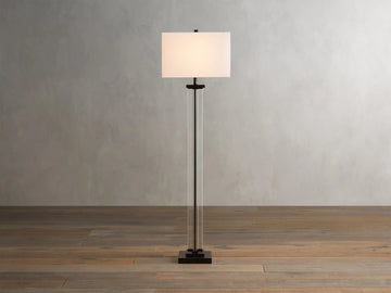 Dawson Floor Lamp with rectangular white shade, clear crystal and iron stand, on wooden floor, against a light gray wall.